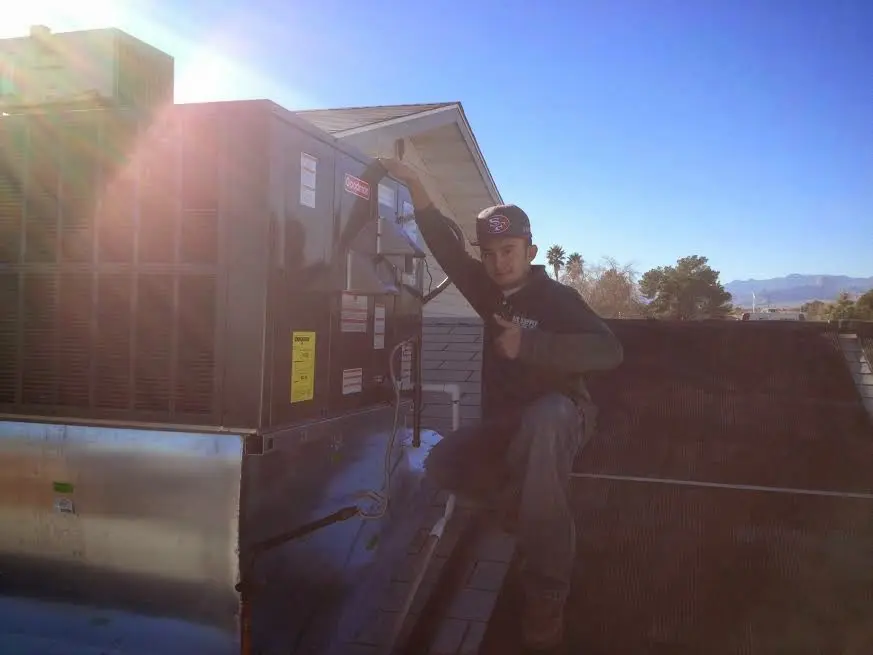 HVAC technician performing Boiler Repair on a rooftop unit in Shelby